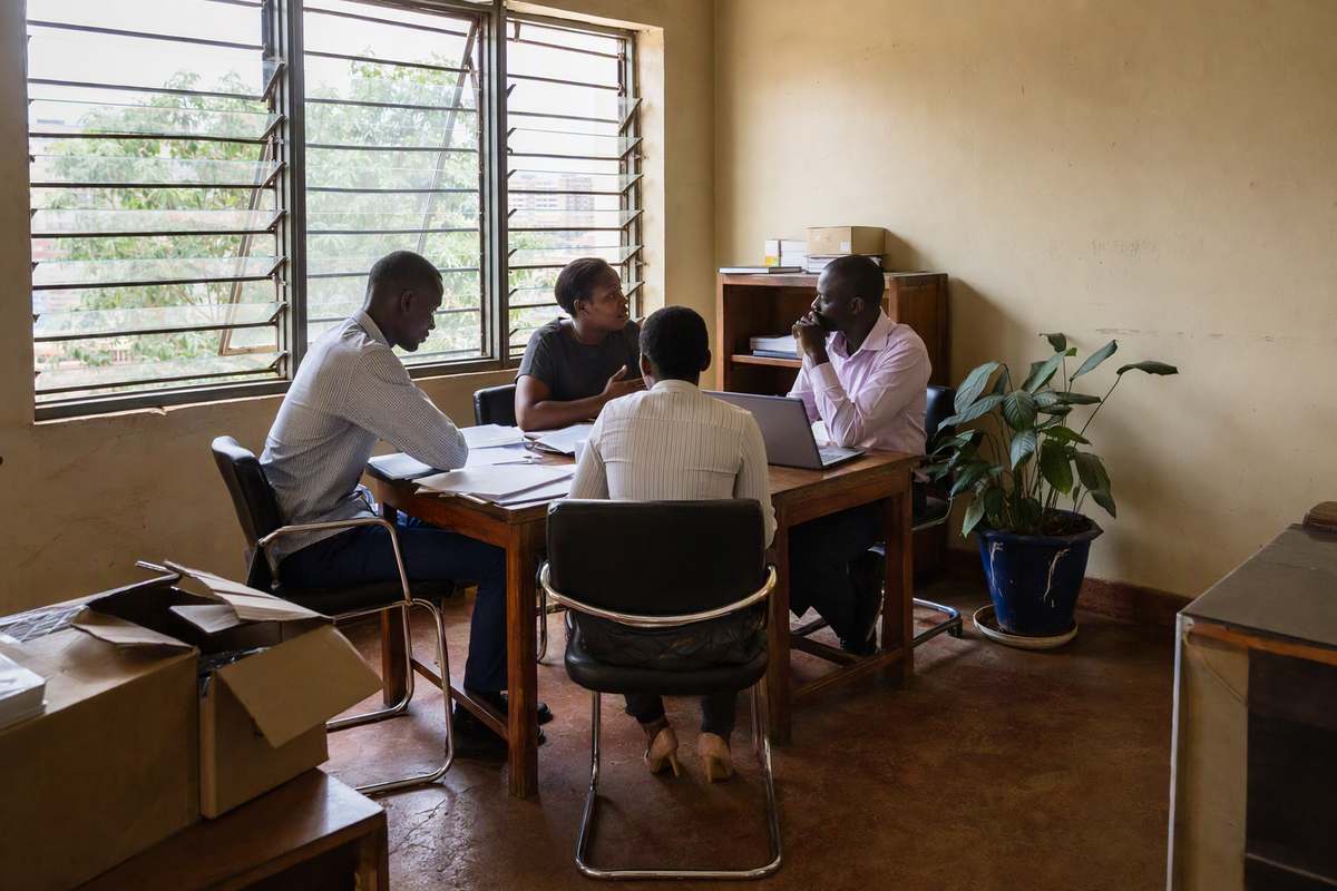 Colleagues in discussion around a table in Kampala