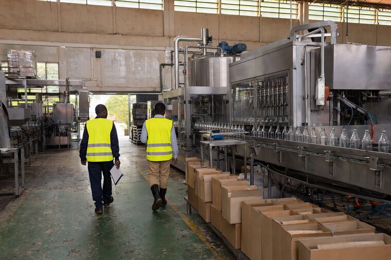 Two colleagues walking the length of a production line